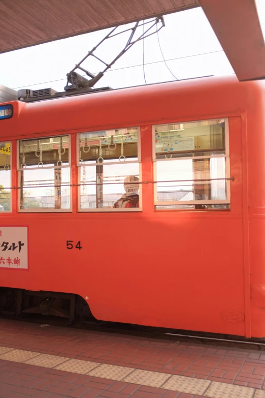 an orange tram has an asian writing on it