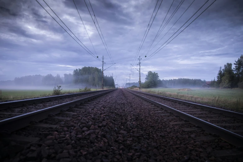 fog is shining in the background near some train tracks