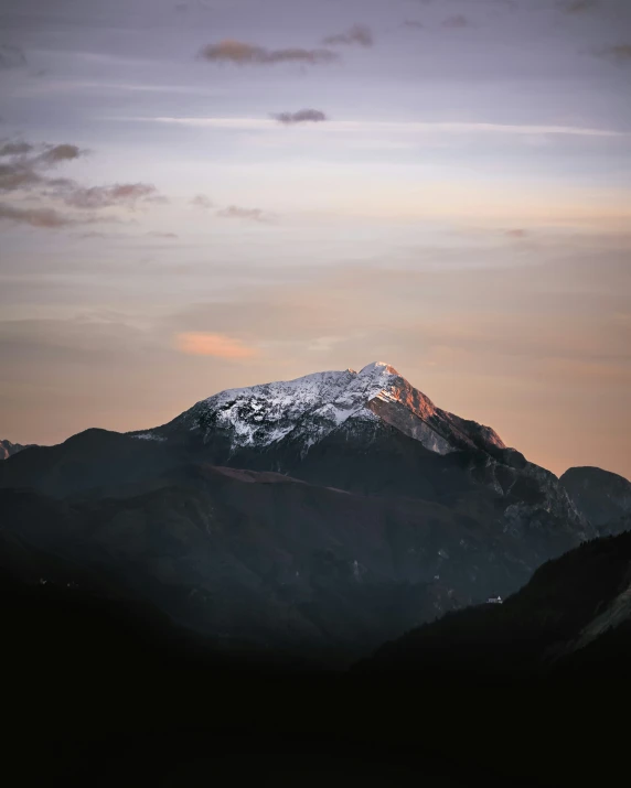 there is a snow - covered mountain seen from the top of a hill