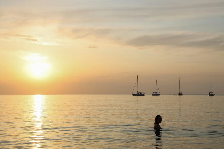 there is a sunset over a beautiful bay with sailboats