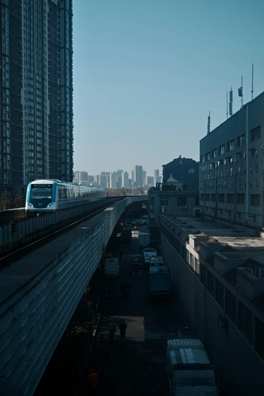 a train running on railroad tracks next to tall buildings