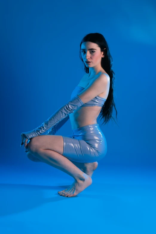 woman wearing silver pose on blue background
