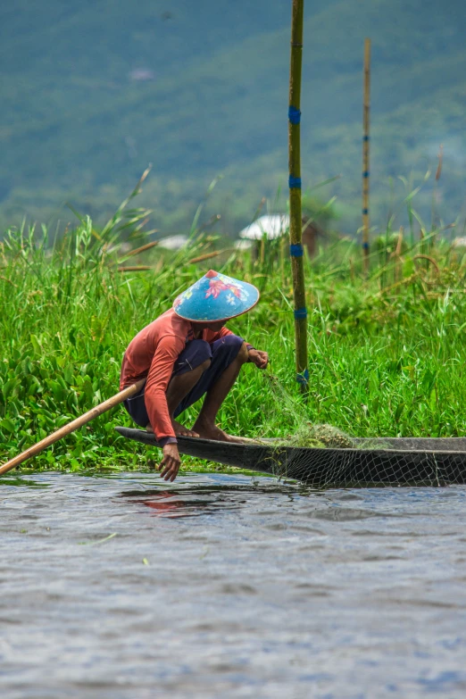 a woman with a blue umbrella is standing in a boat