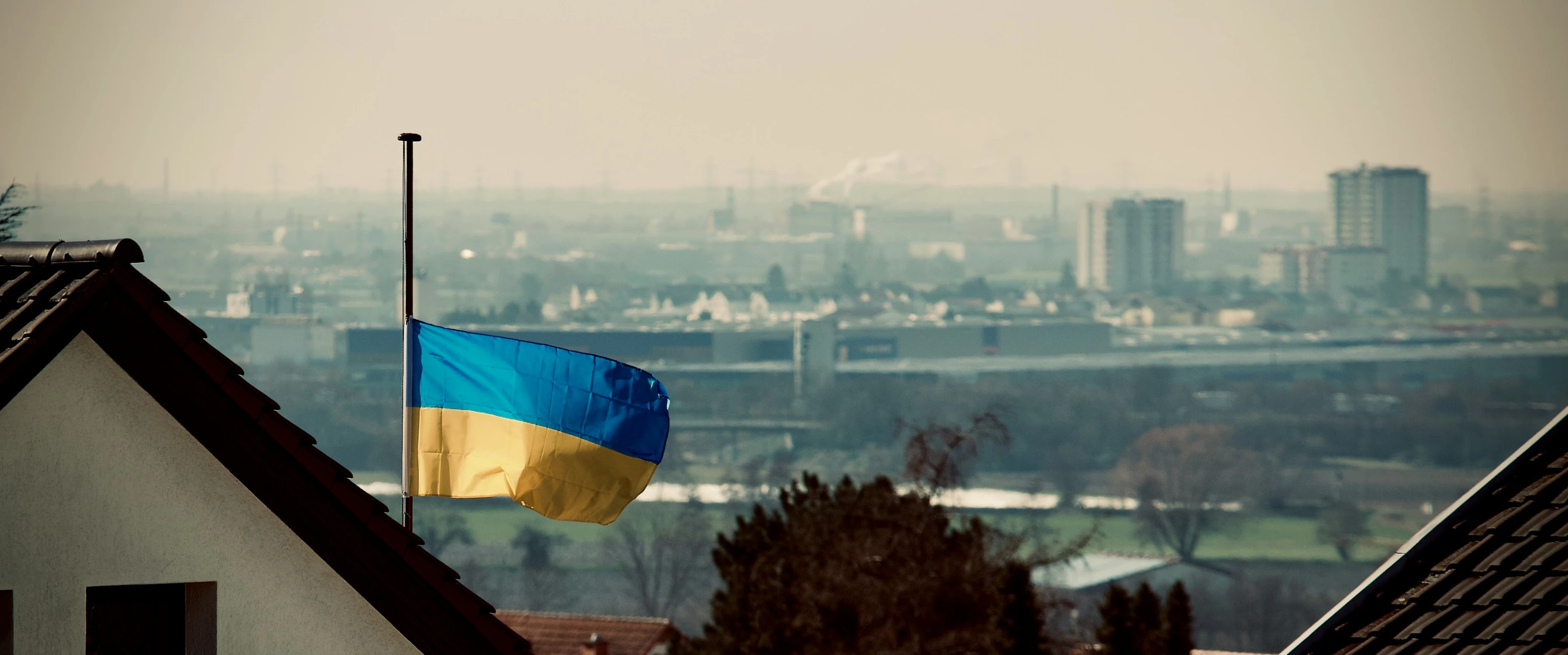 an ukraine flag is seen above some buildings