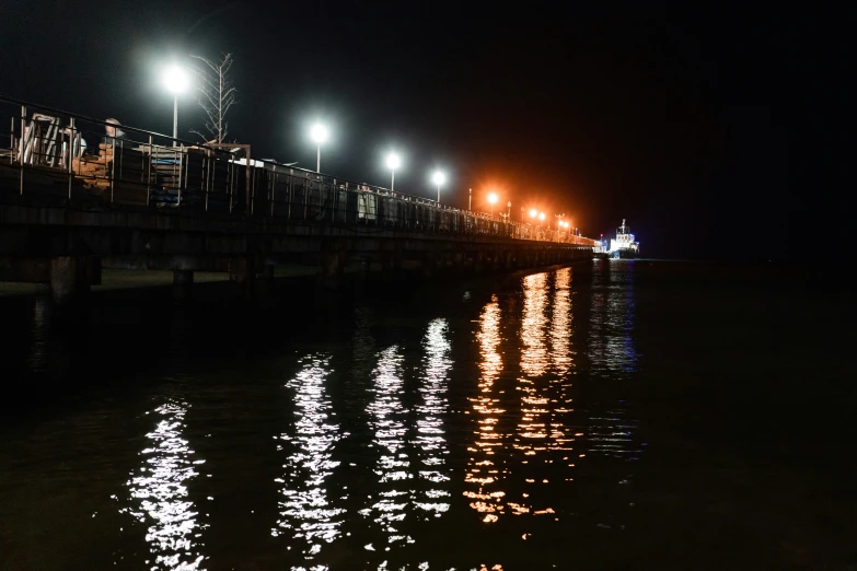 the lights shine brightly over a bridge over water