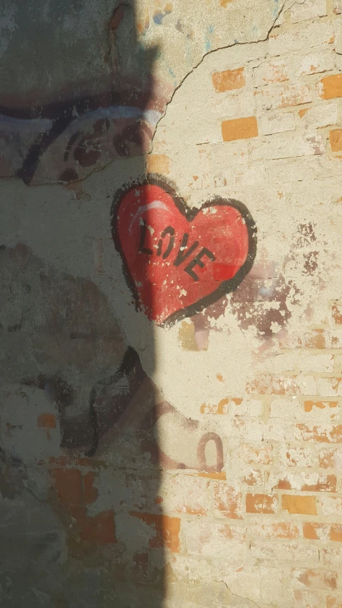 a heart with the word love is painted on a wall
