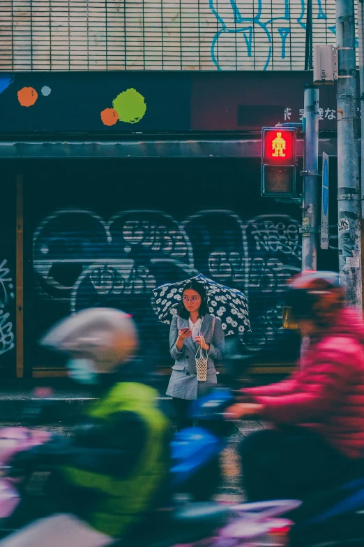 many people with umbrellas walking and on motorcycles