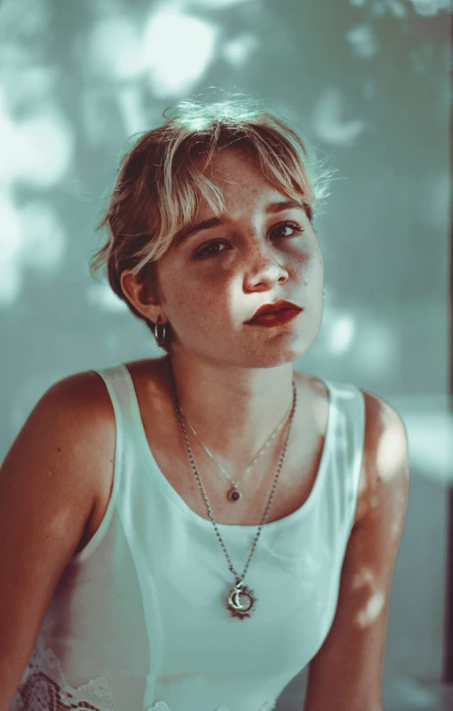 a young woman wearing a white shirt posing for a picture