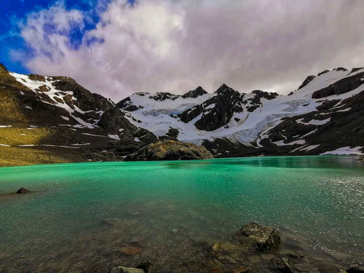 a landscape scene with blue water and mountains