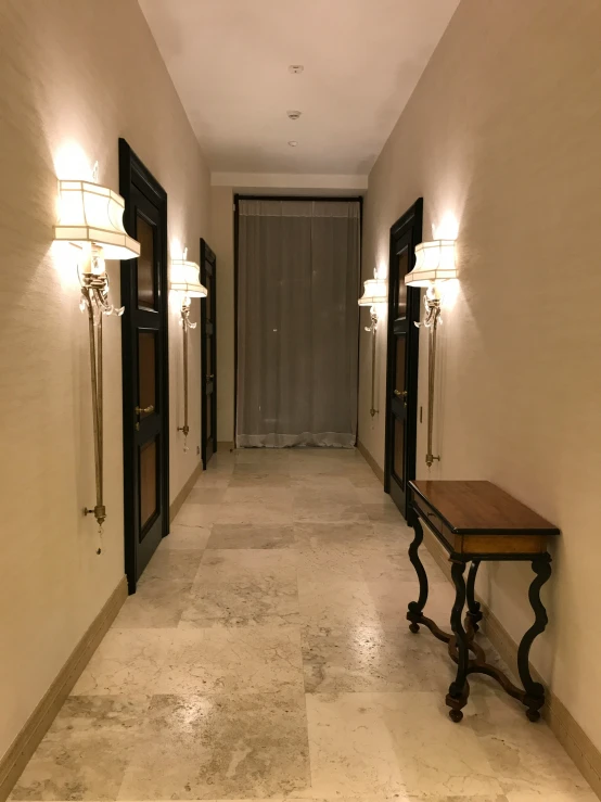 the long hallway is empty except for two lights on either side