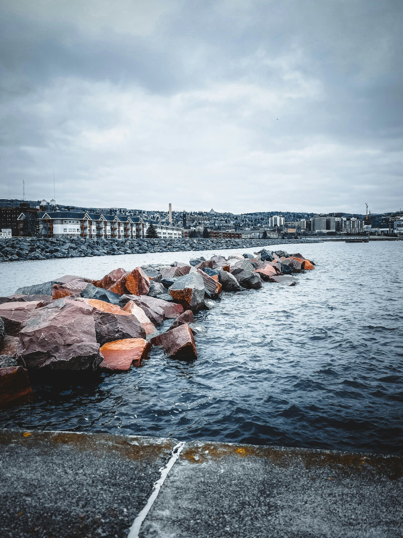 the rocks on the edge of a harbor break