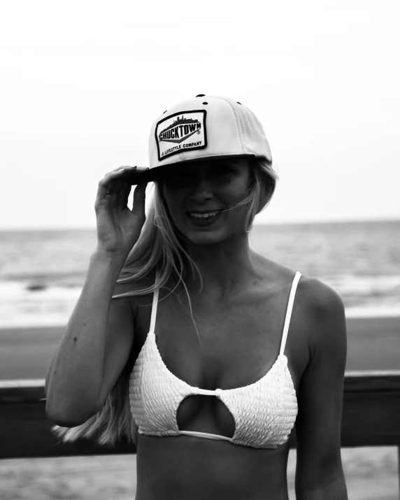 a woman in a white bikini and a brown hat