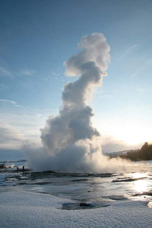 a large steam pipe emits water while it is surrounded by snow