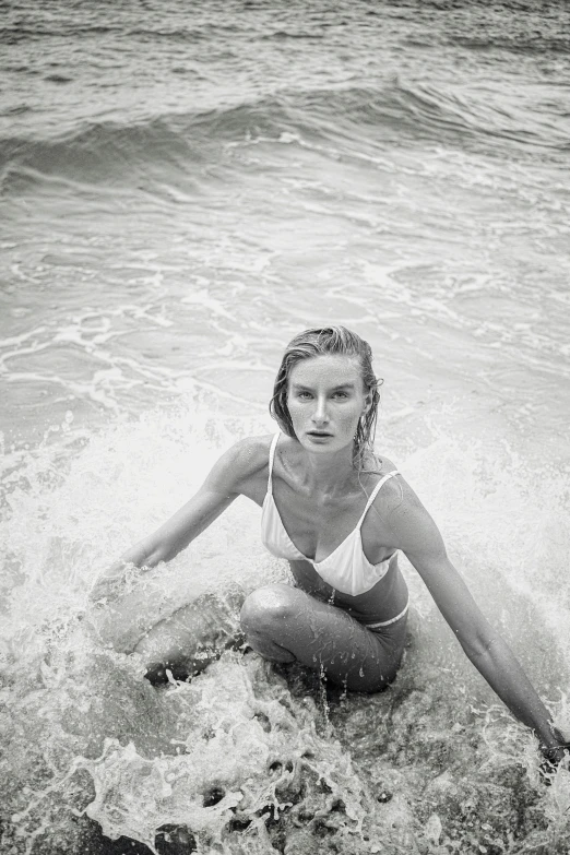 black and white image of girl laying down on surfboard