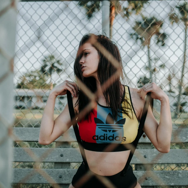 woman in adidas  with fence in the background