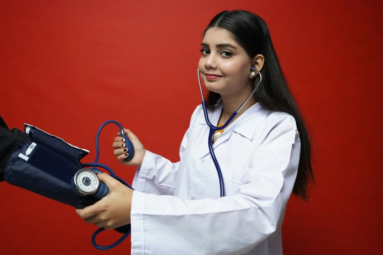 a person in a lab coat using a handheld stethoscope