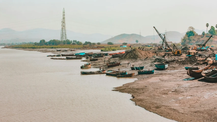 boats tied to shore in front of water