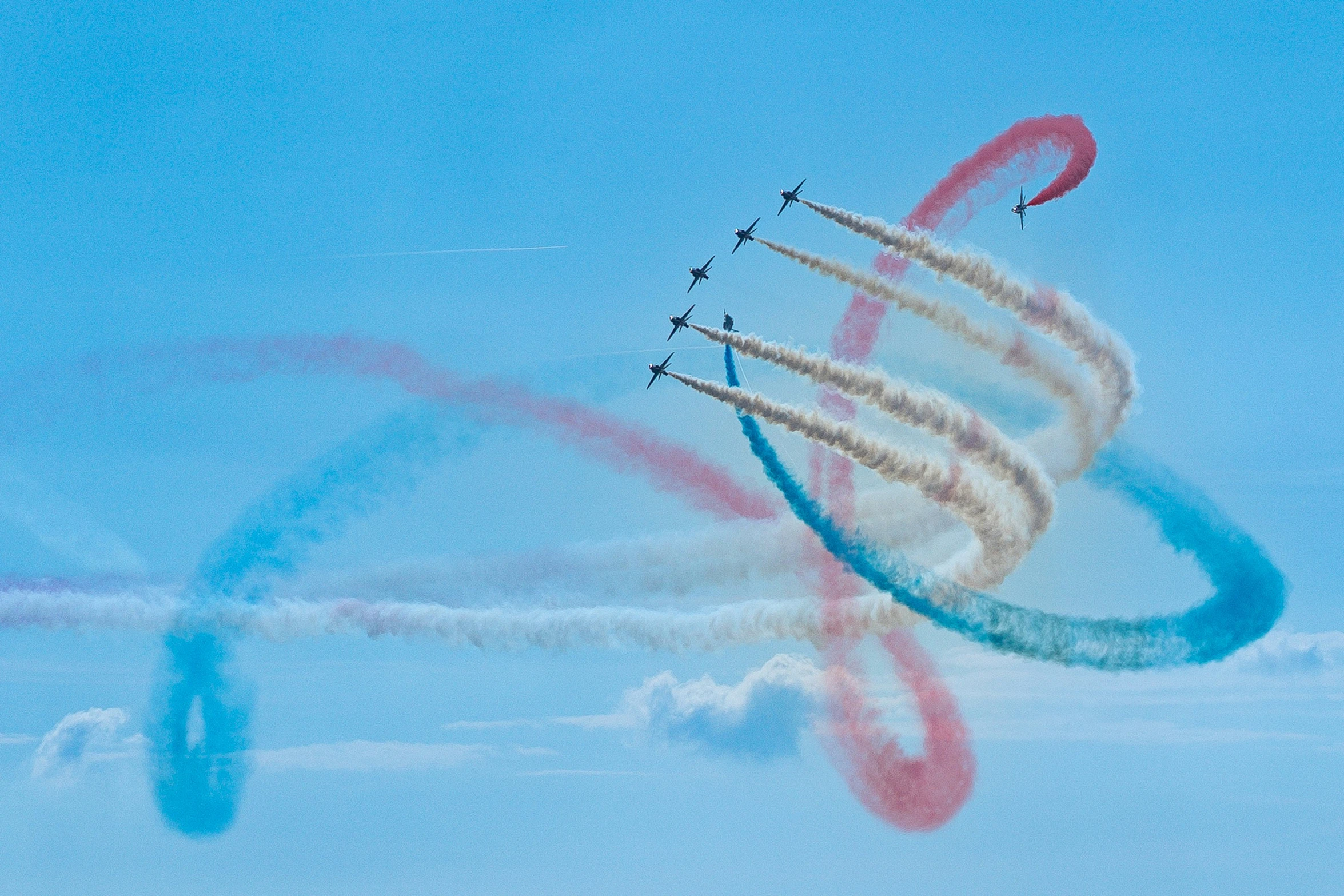 jets are seen flying in formation behind colored arrows