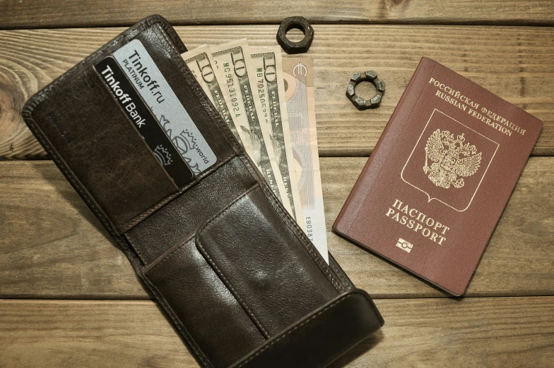 passport, keys, and a wallet are sitting on a table