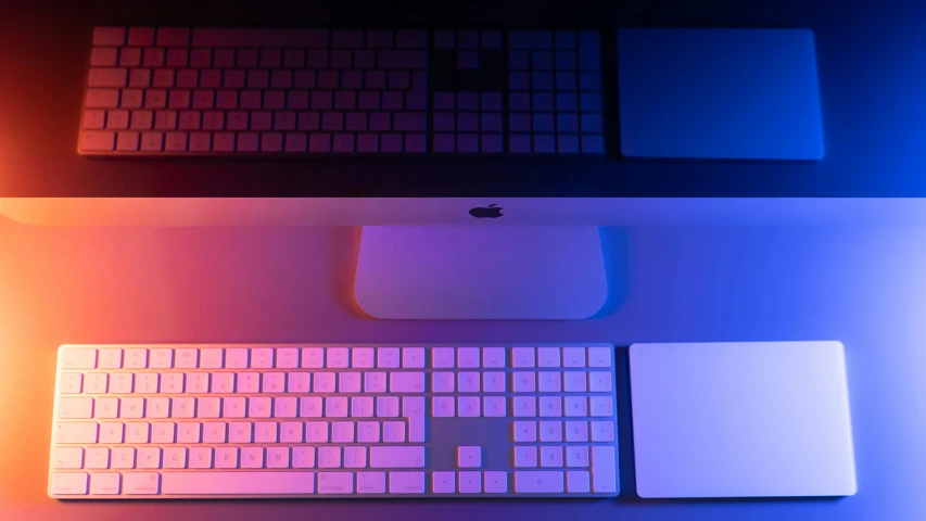 two keyboards sitting next to each other under lights