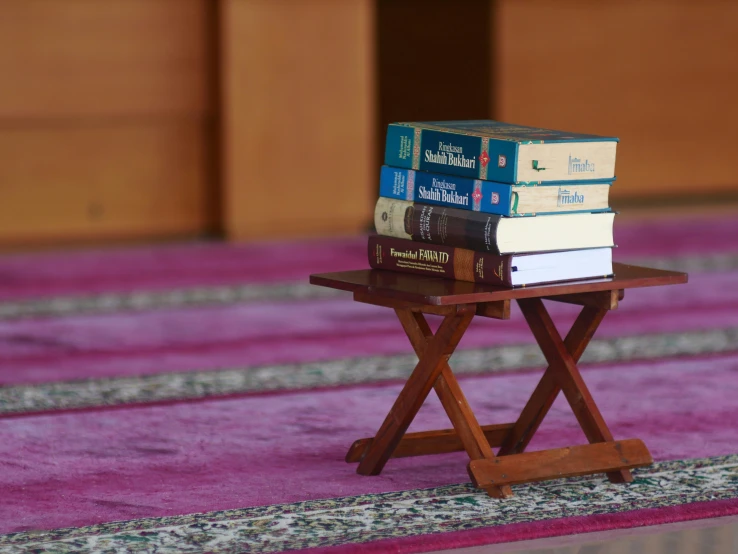 a small table with a stack of books on top of it