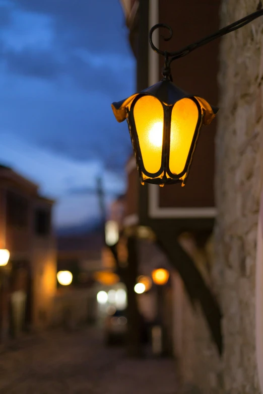 a yellow light attached to the side of a stone building