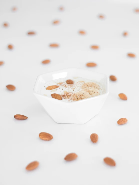 a white bowl with nuts in it on a white background