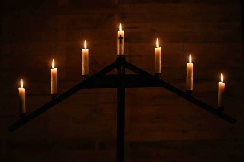 seven lit candles lit up in a triangular manner