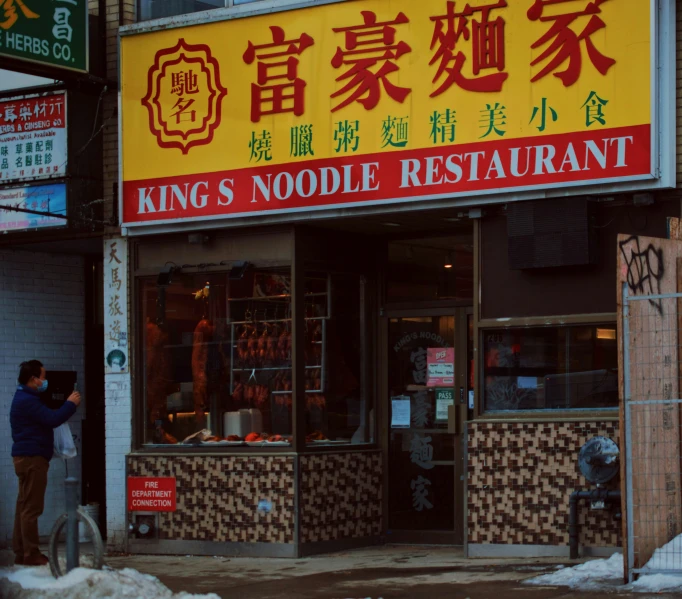 people outside of a noodle restaurant in the winter