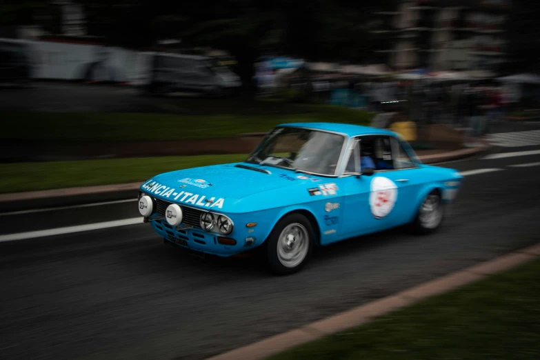 an older model car racing on a road