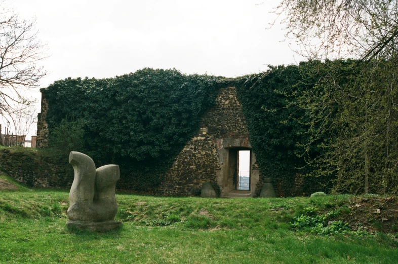 an artistic stone sculpture sitting in a grassy area