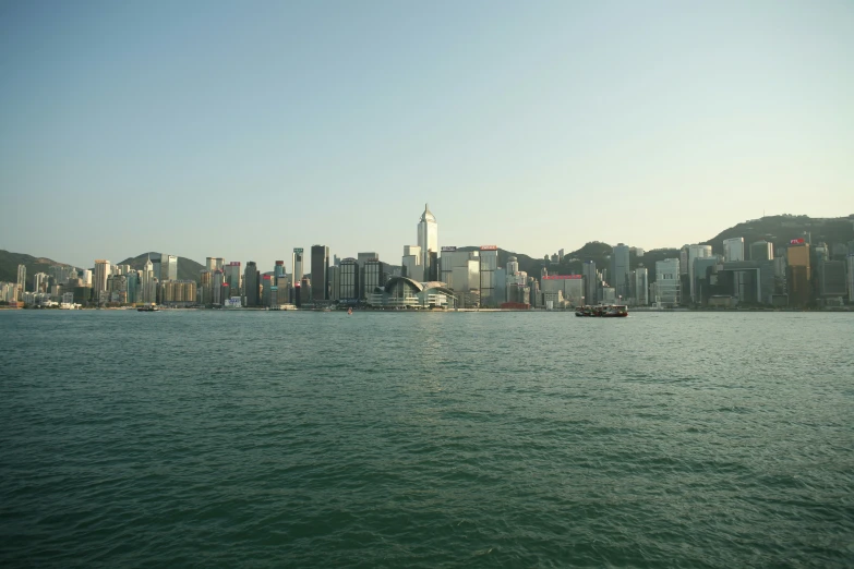 a view from the water of buildings and some hills