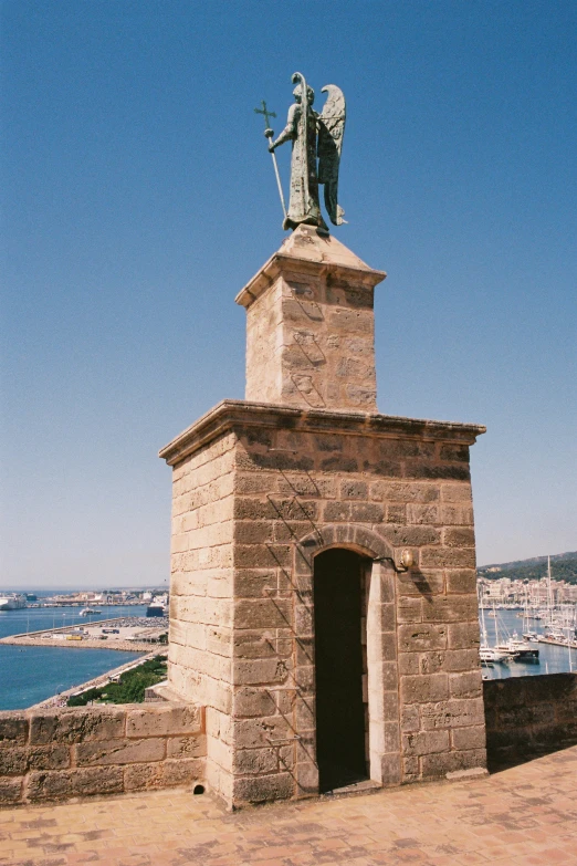 a statue stands near the wall at the beach