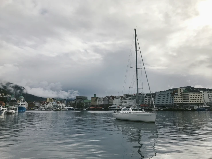 sailboats are sailing on the water in a harbor