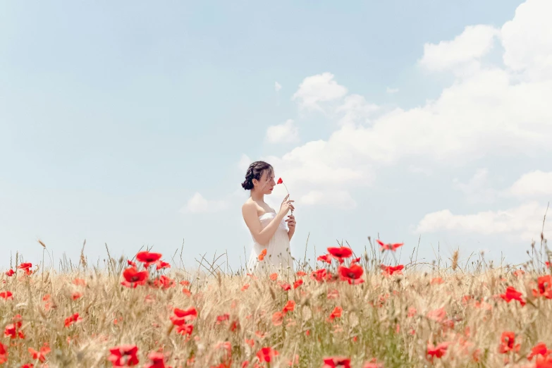 the girl in the field looks at the flowers