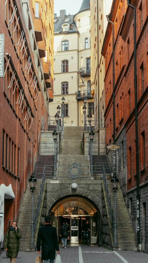 an old city street with some people walking up and down the stairs