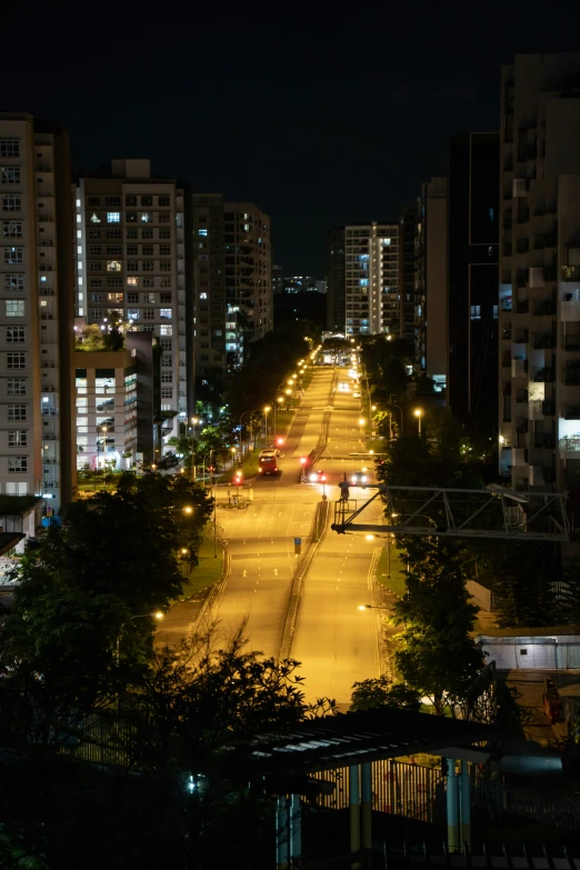 a street with a few buildings and trees at night
