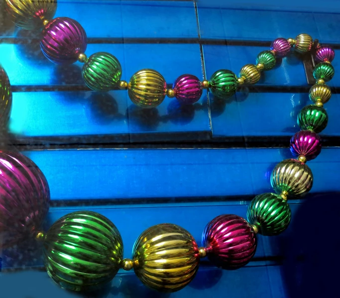 a multi - colored beaded necklace hanging in a window