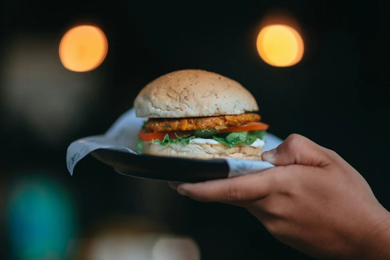 a close up of a hand holding a half eaten burger