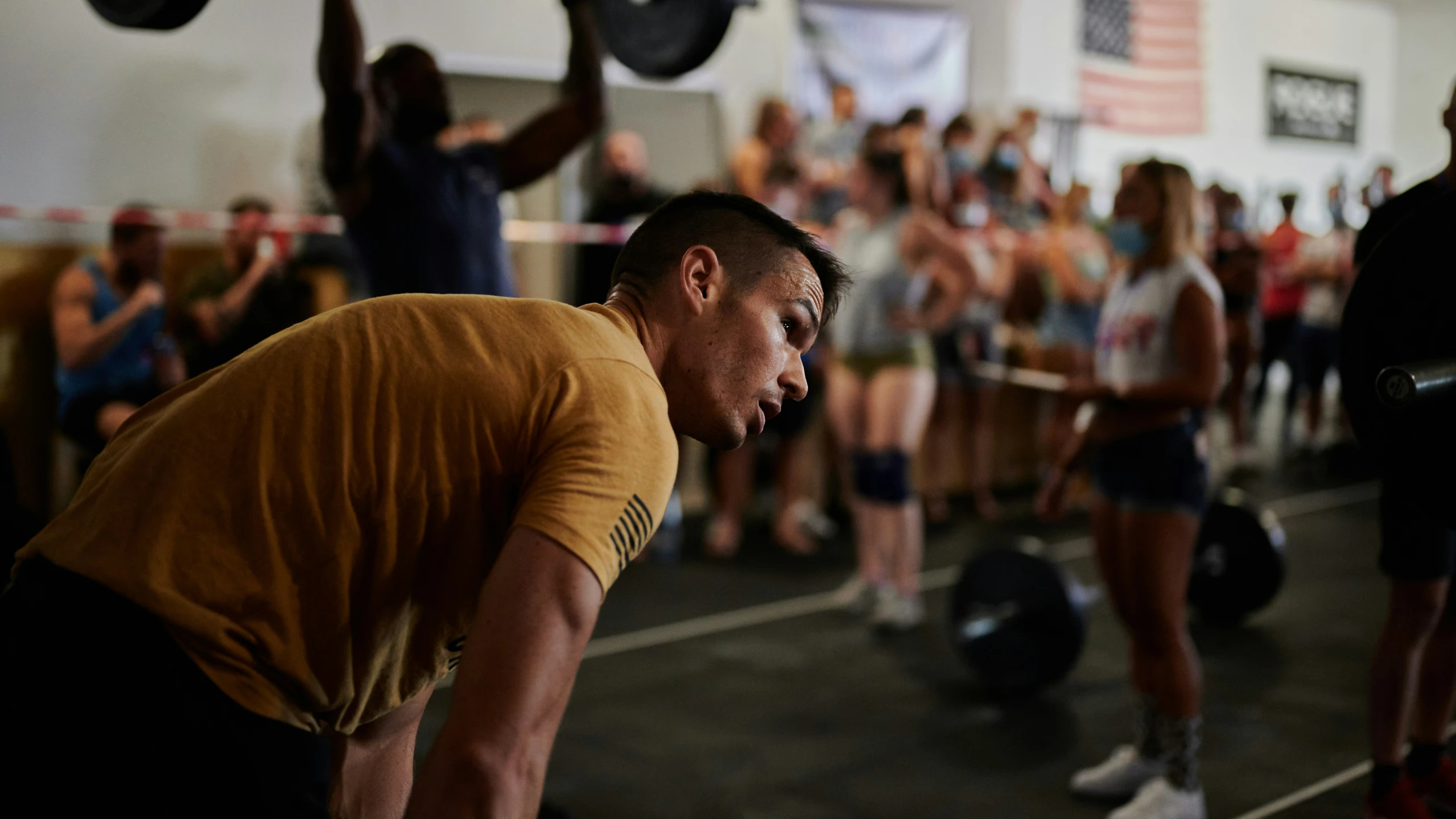 people in a gym during the day with kettlebells