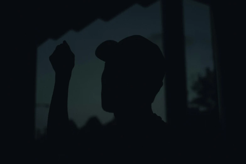 silhouette of a man raising his arms at night