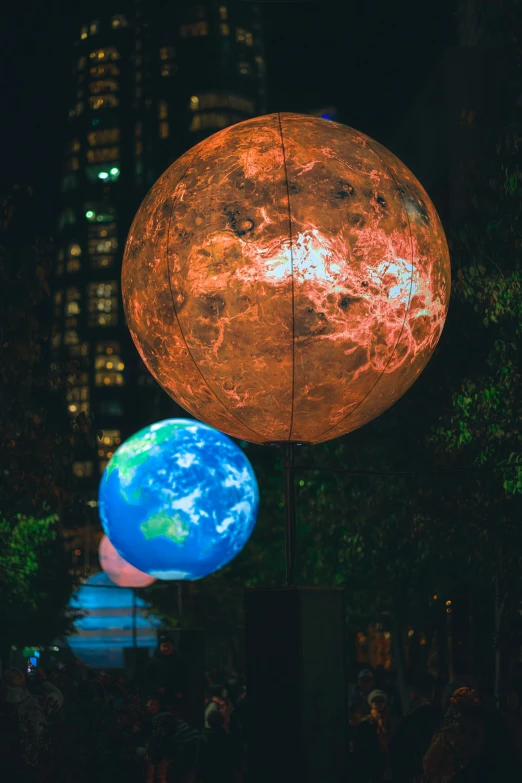 the globe and earth are hanging on poles at night