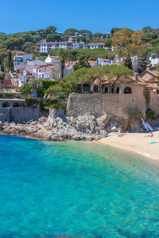 a sandy beach is seen next to the sea with buildings on top