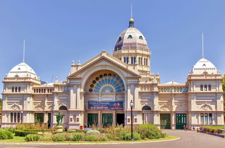 a large building with a circular roof near plants