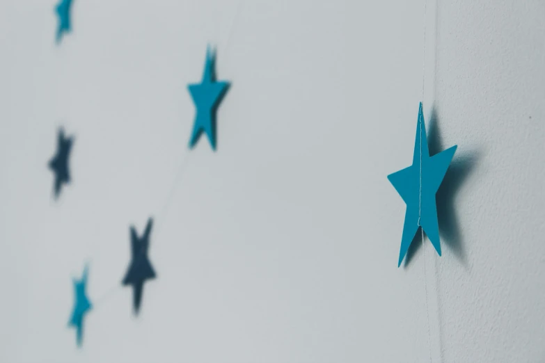 blue paper stars are hanging from a string