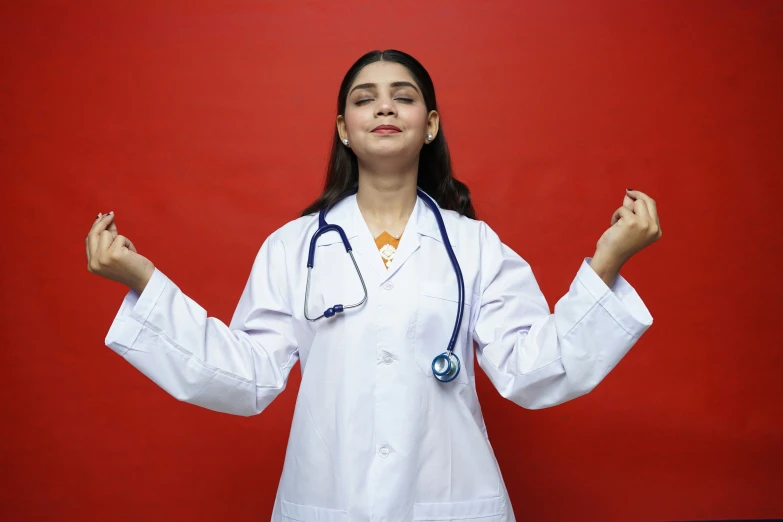 girl with white lab coat and blue tie standing in front of a red wall