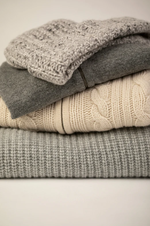 a stack of three sweaters that are folded up