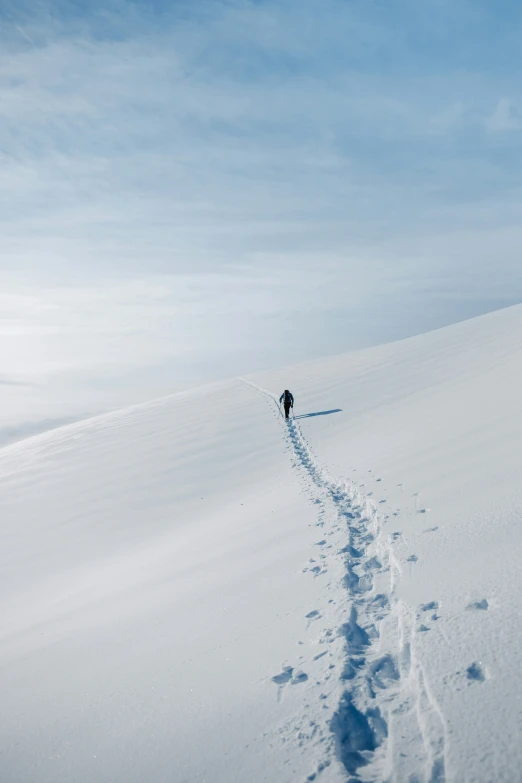 a lone skier makes their way down the snowy hill