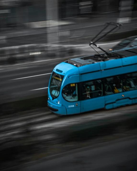 a long blue bus is driving on the street