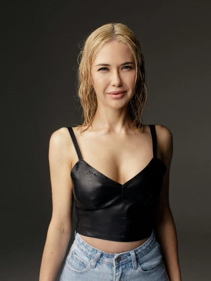 a woman wearing a black crop top and jean shorts